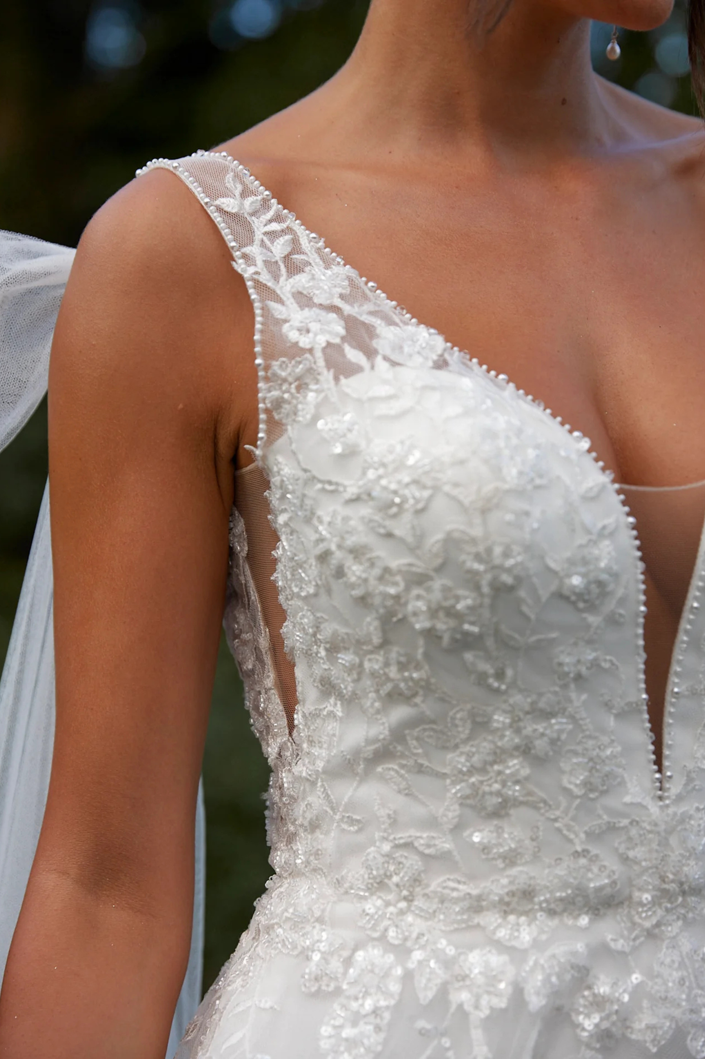 Close-up of a white wedding dress with intricate detailing.