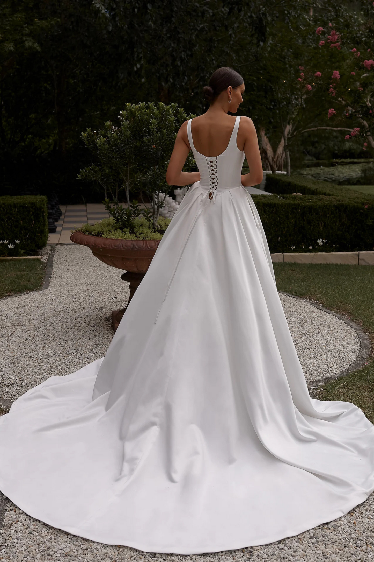 Woman in a white wedding dress standing in a garden setting