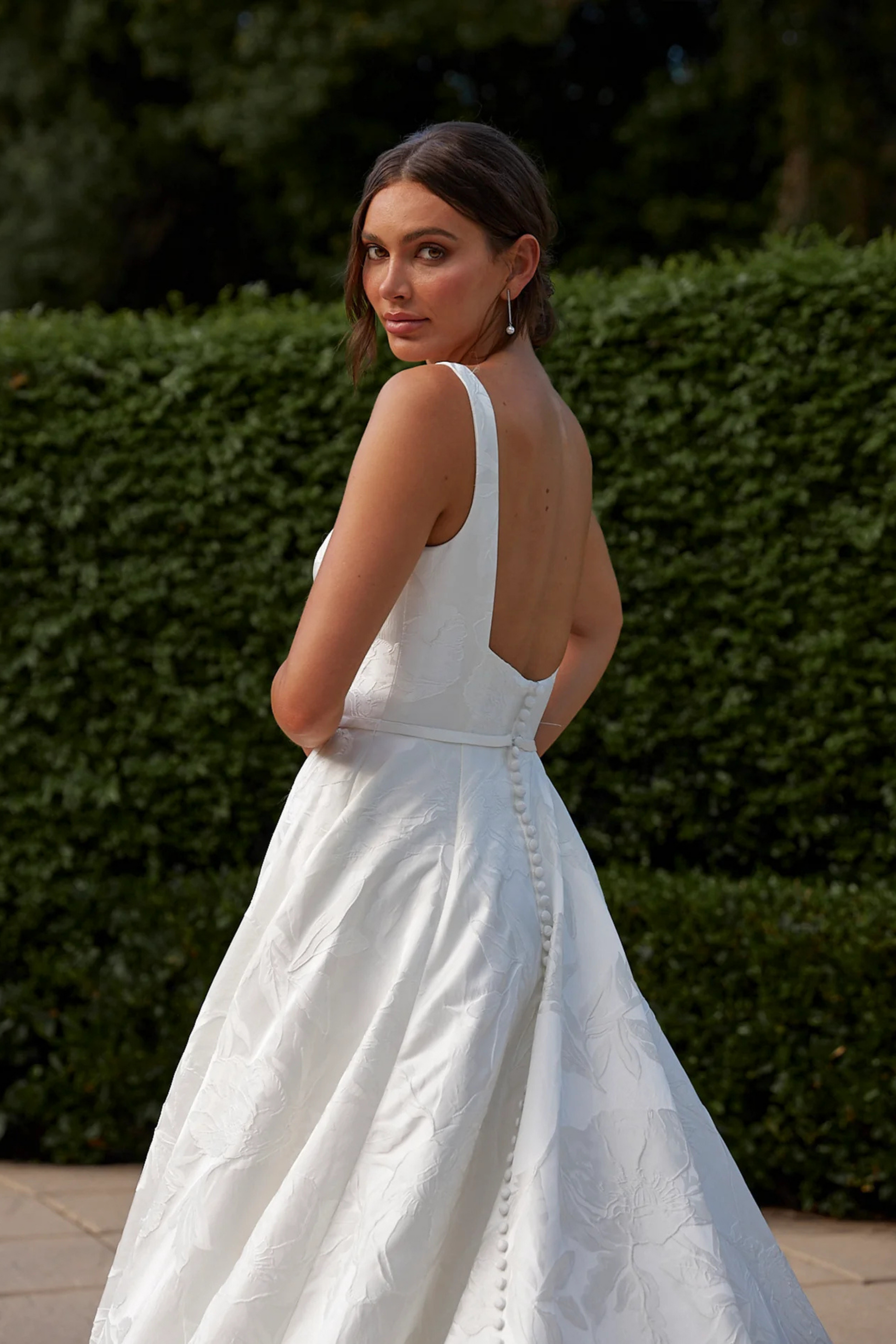 Bride in a white wedding dress showing the back of the gown