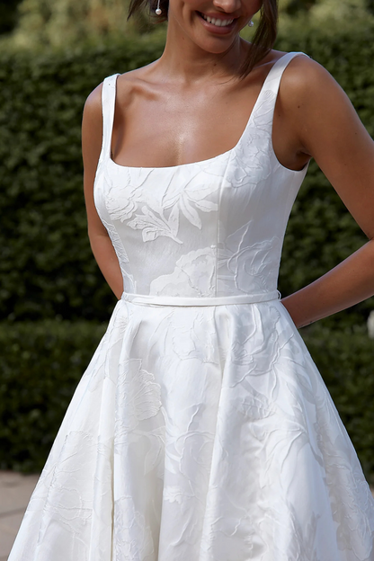 White floral wedding dress worn by a bride, front close up detailing 