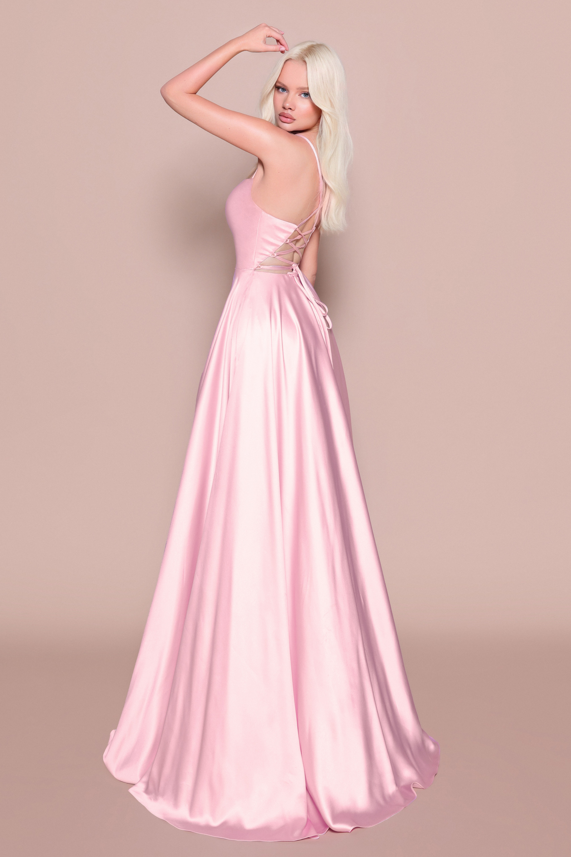Woman wearing a pink satin evening/bridesmaid gown showing the back of the dress