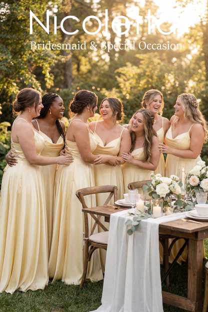Group of bridesmaids in lemon dresses standing around a table with floral arrangements outdoors.