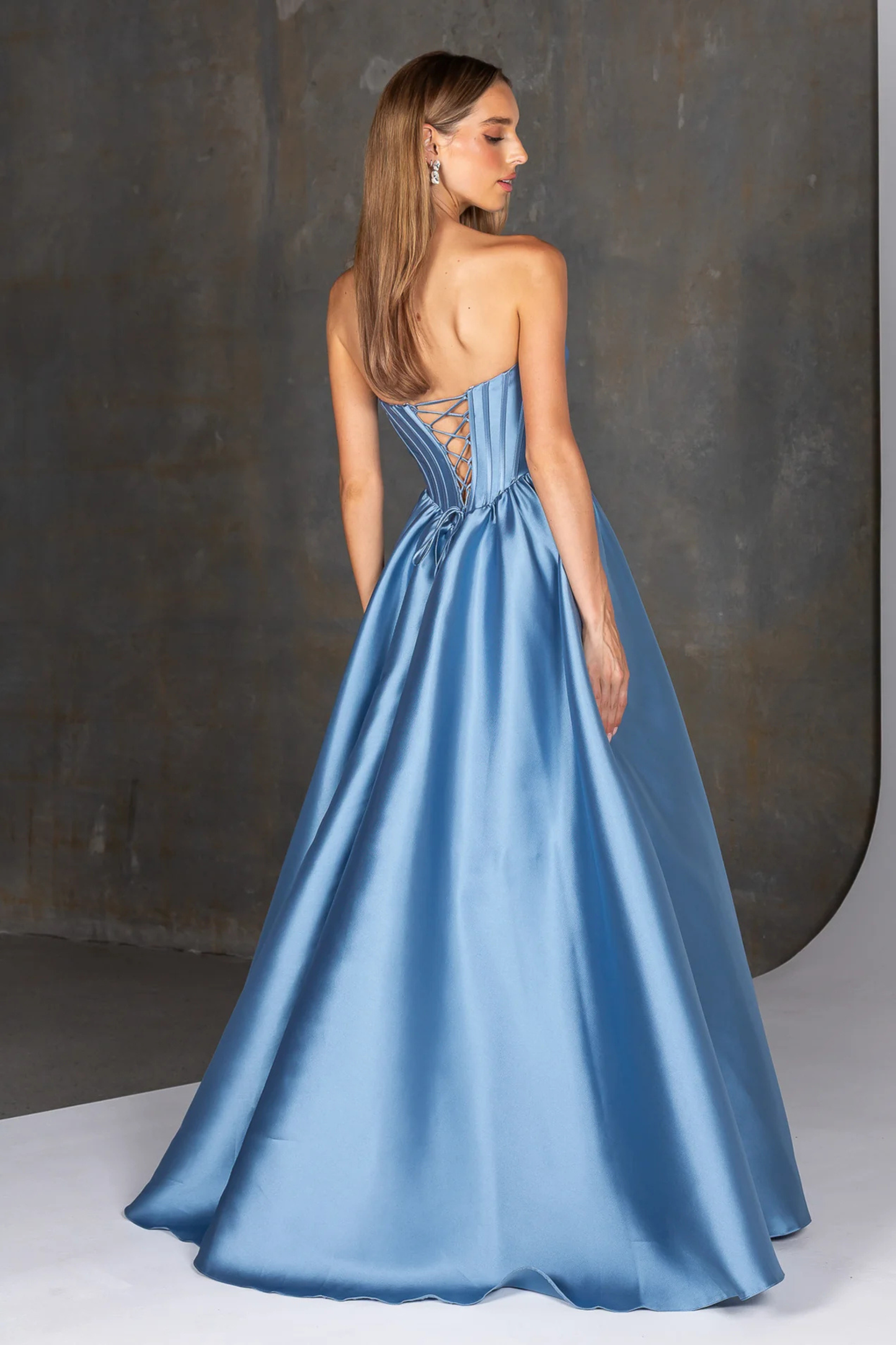 Woman wearing a blue evening gown with a dark background