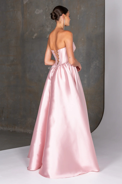 Pink satin gown with intricate back design on a neutral background