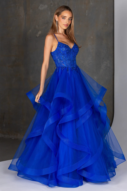 Royal blue evening gown featuring a fitted embellished bodice with delicate beading and thin spaghetti straps, flowing into a dramatic multi-layered tulle skirt with soft cascading ruffles. A statement formal dress ideal for prom, gala, or special occasion wear, showcasing elegant movement and a bold, vibrant color.