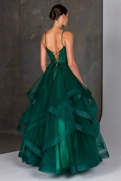 Emerald green evening gown featuring a fitted embellished bodice with delicate beading and thin spaghetti straps, flowing into a dramatic multi-layered tulle skirt with soft cascading ruffles. A statement formal dress ideal for prom, gala, or special occasion wear, showcasing elegant movement and a bold, vibrant color. Showing the back design of the gown.