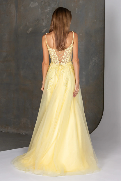 Woman wearing a yellow evening gown with a textured gray background