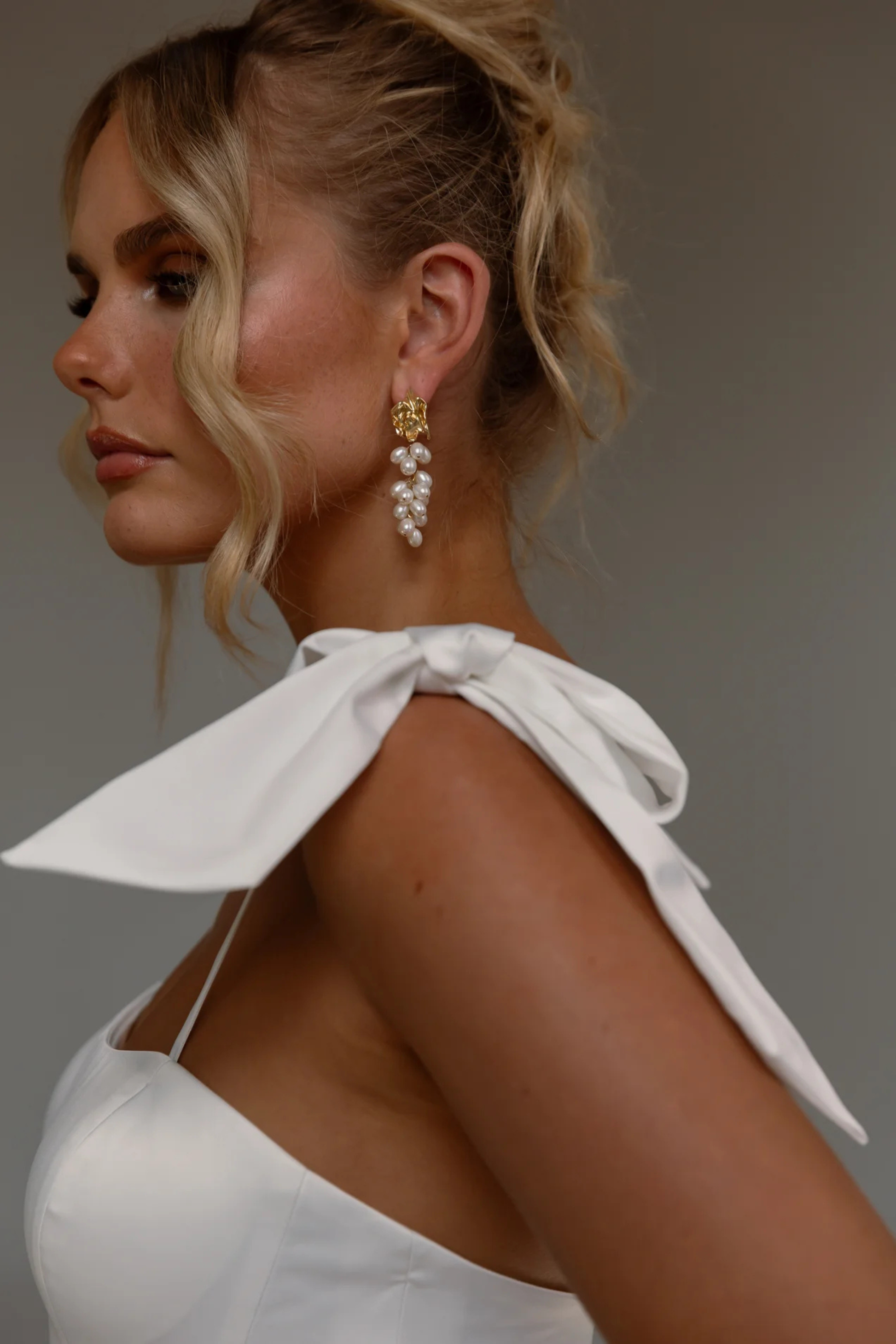 Tania Olsen Designs Anne wedding dress in vintage white featuring a square neckline, detachable bow straps, satin A-line skirt and chapel-length train.
